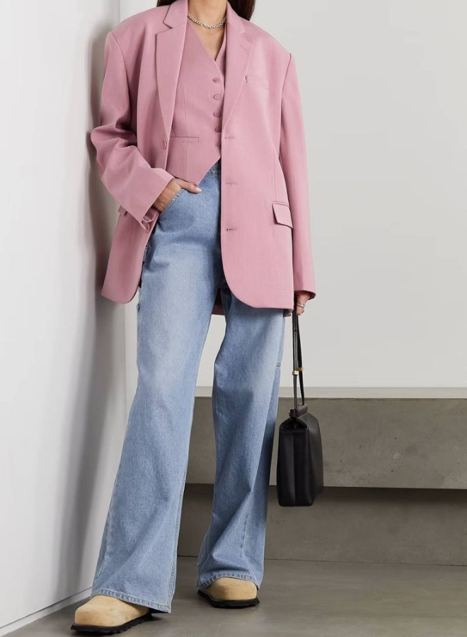 Wanita dengan pakaian mauve dan celana denim.