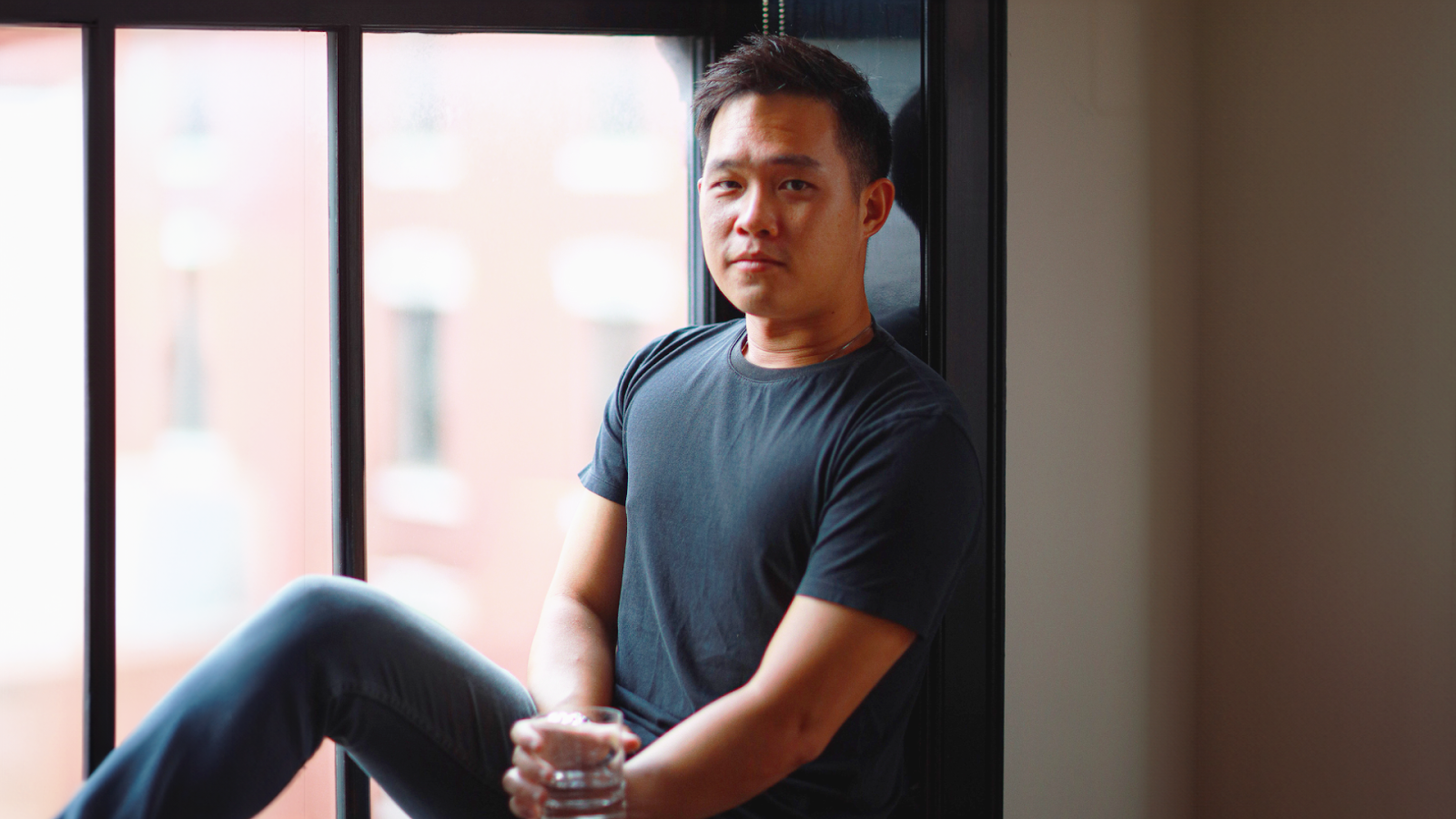 Chester Yow, a Licensed Associate Real Estate Broker and Founder of the Chester Yow Team at SERHANT, who overcame early challenges in the U.S. such as racial discrimination and cultural differences, smiling confidently in professional attire.