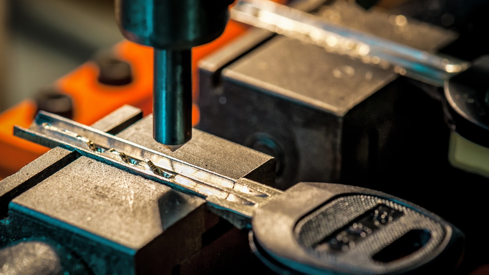 A duplicate car key is being cut with a specialized tool.