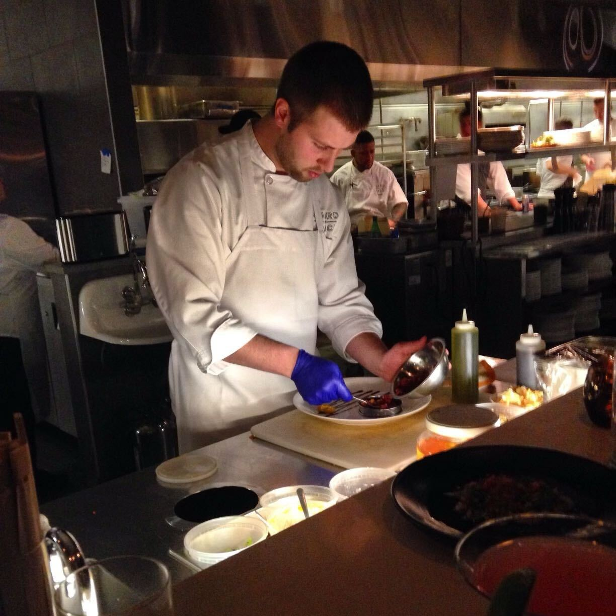 Picture of Colby preparing food in a busy restaurant kitchen.