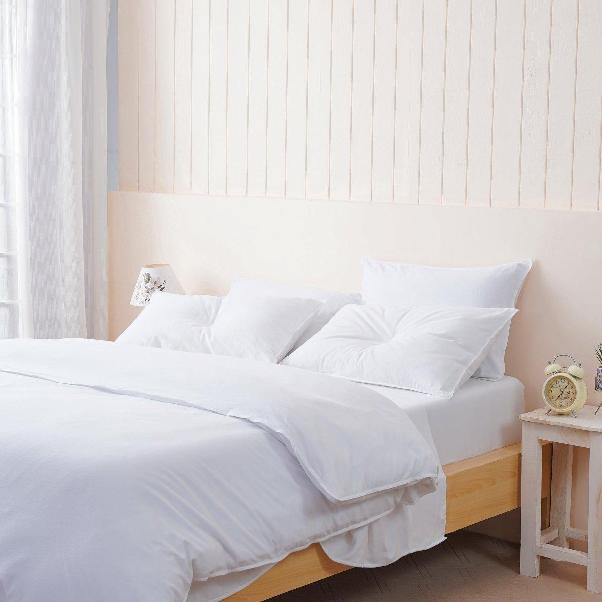 A bed with white sheets and pillows