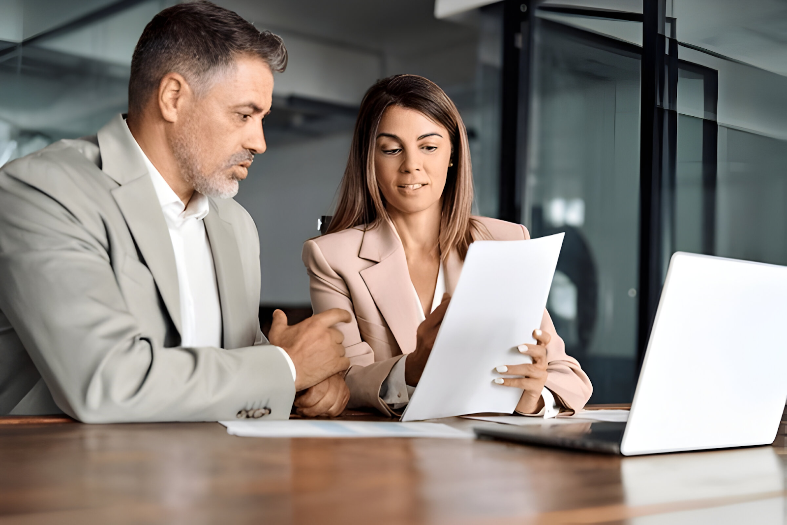 Two accountants reviewing documents and discussing strategies to handle international tax issues in a modern office setting.