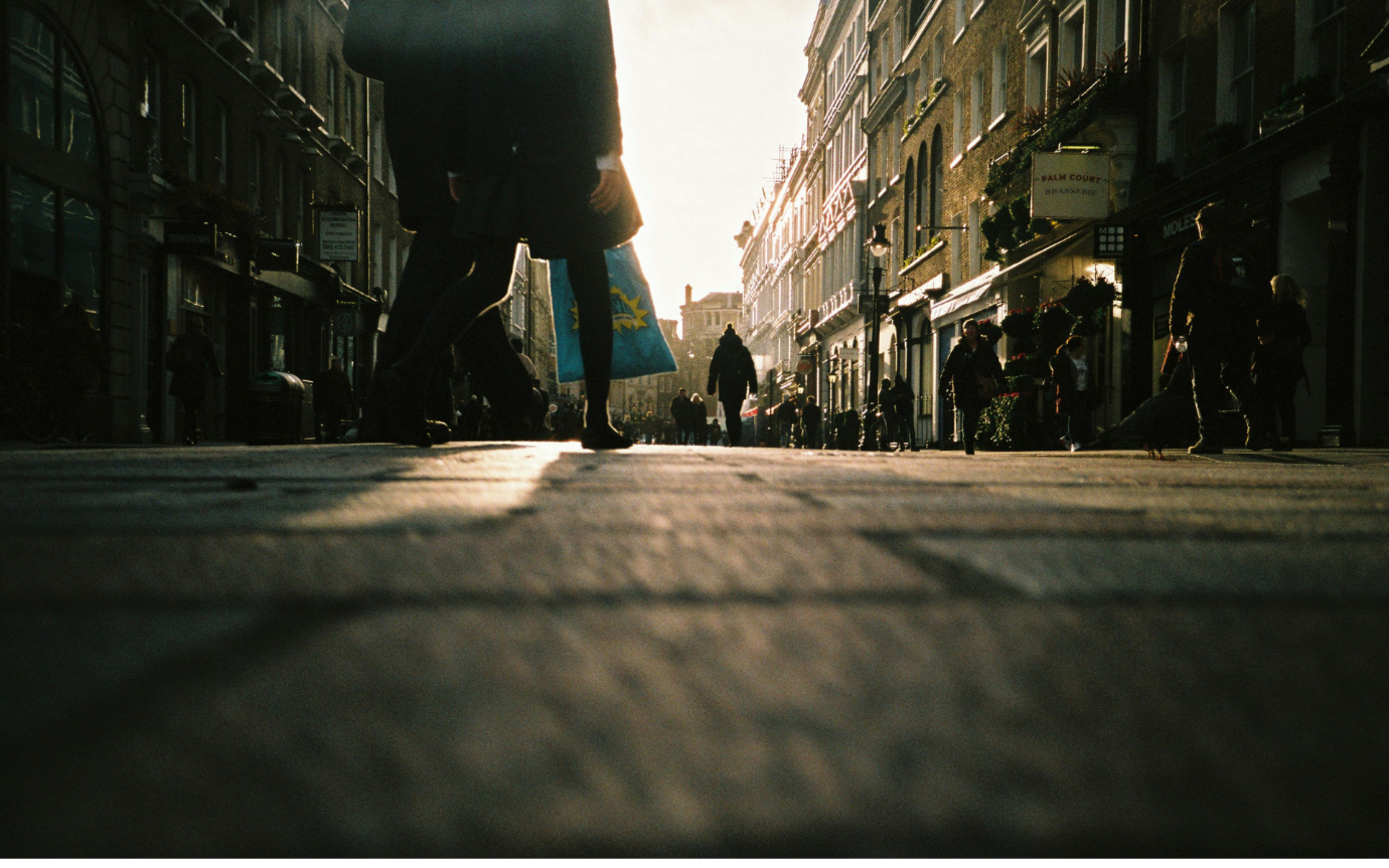 People walking on a sidewalkDescription automatically generated