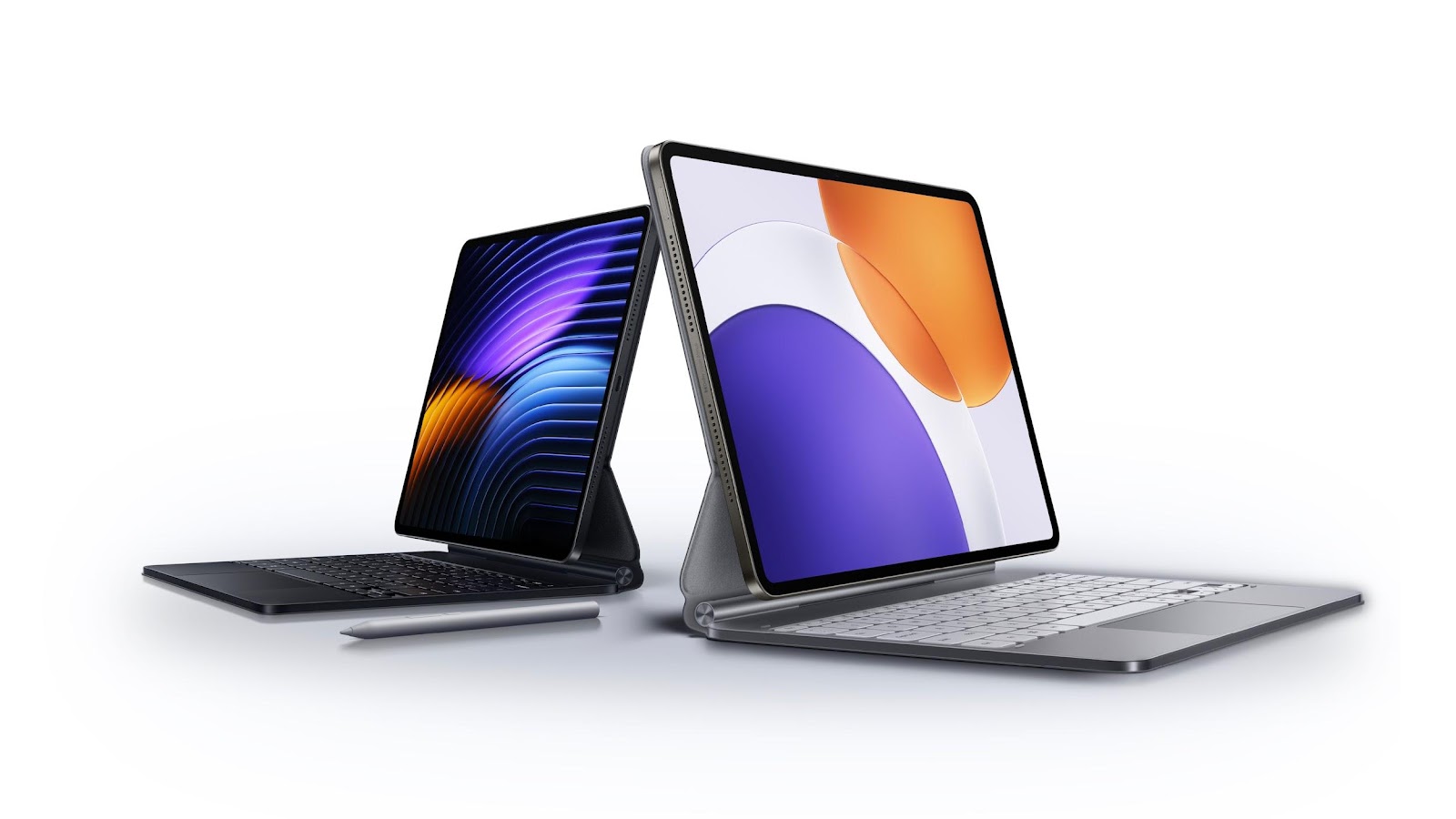 Two tablets are placed back to back, one with a dark keyboard and a silver stylus, and the other with a light-colored keyboard, displaying different graphic designs on the screen.