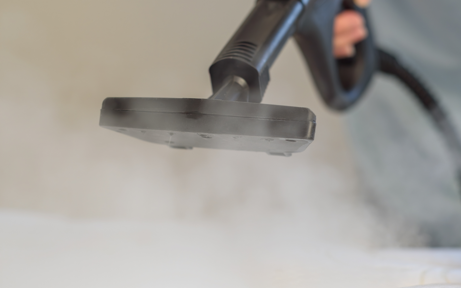Close-up of steam cleaner sanitising a mattress, removing dust mites and allergens for deep hygiene