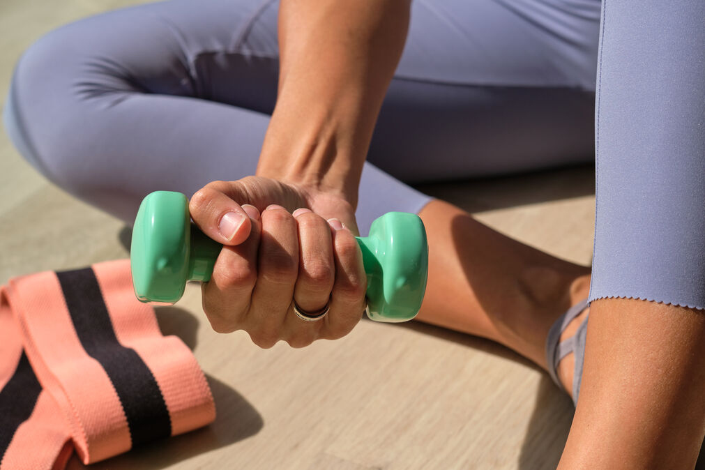 Valgus Extension Overload Exercise - lady holding a dumbbell