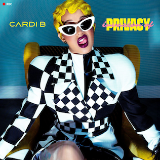 Cardi B's 'Invasion of Privacy' album cover featuring the artist with a fierce expression, wearing a checkered suit, white sunglasses, yellow hair, and sitting in a yellow armchair.