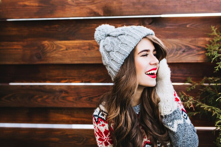 Pretty girl with long hair in knitted hat and warm gloves