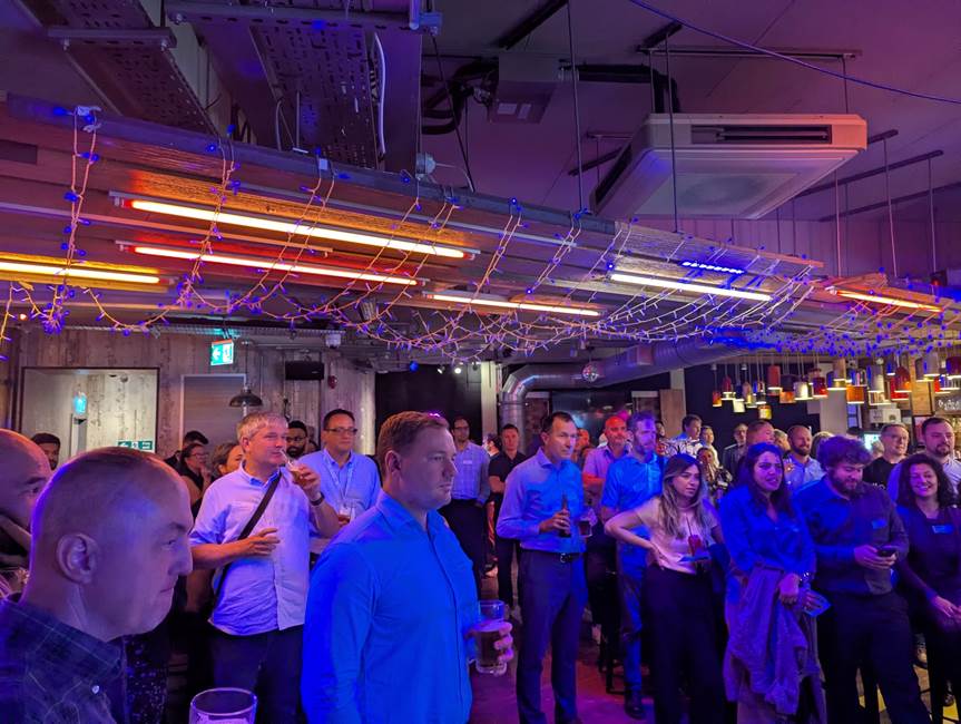 A group of people standing in a room

AI-generated content may be incorrect.