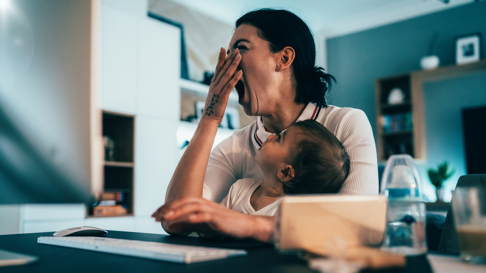 Mom yawning while baby is on her lap // Healthier Baby Today