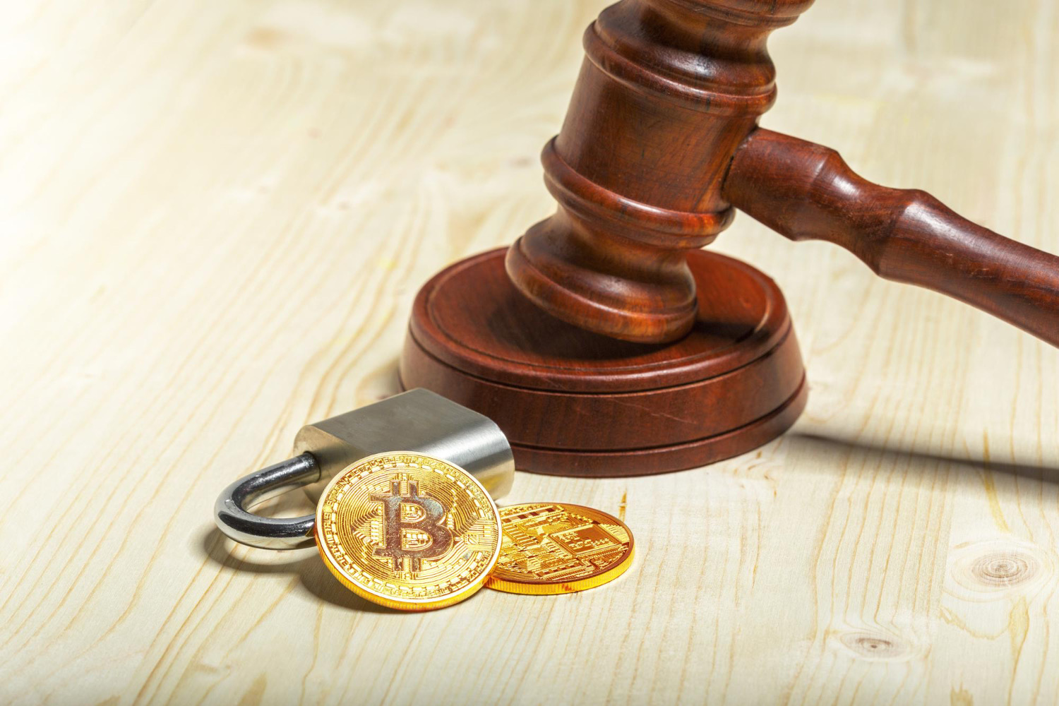Golden Bitcoin beside a padlock and a gavel