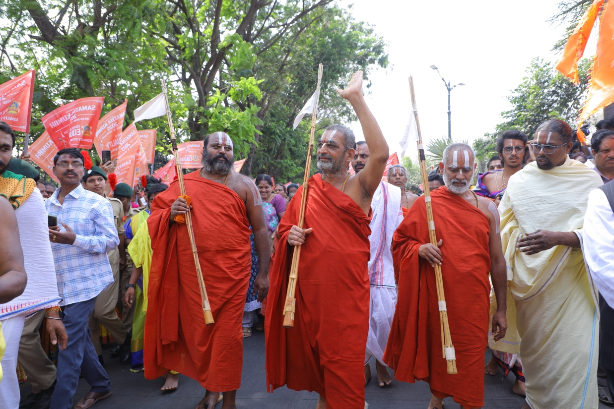 A group of men in red robes walking down the street

Description automatically generated