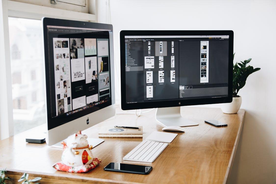 Free A well-organized design workspace with dual monitors and design software on display. Stock Photo