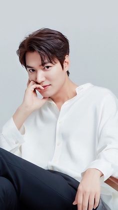 This contain Lee Min Ho  sitting on top of a wooden chair next to a white shirt and black pants