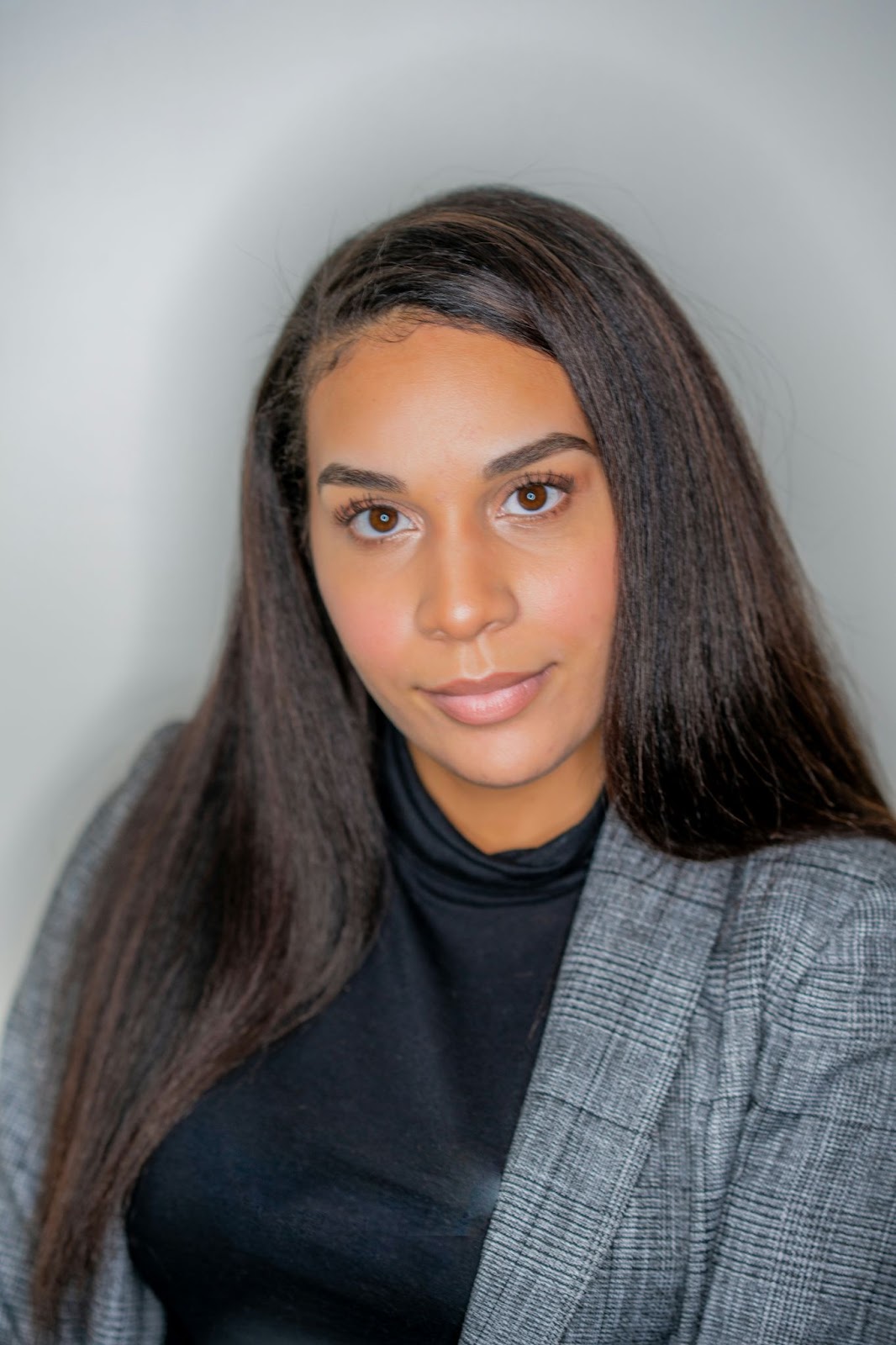 The professional headshot pose against a solid background