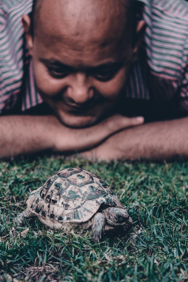 A man trying to observe a baby animal without touching it