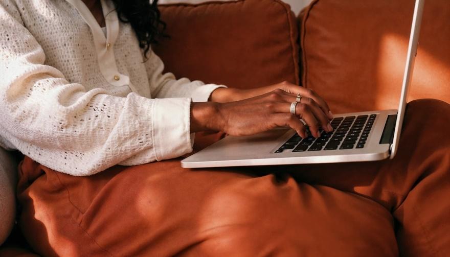 A woman using a laptop to find photo booth rental services
