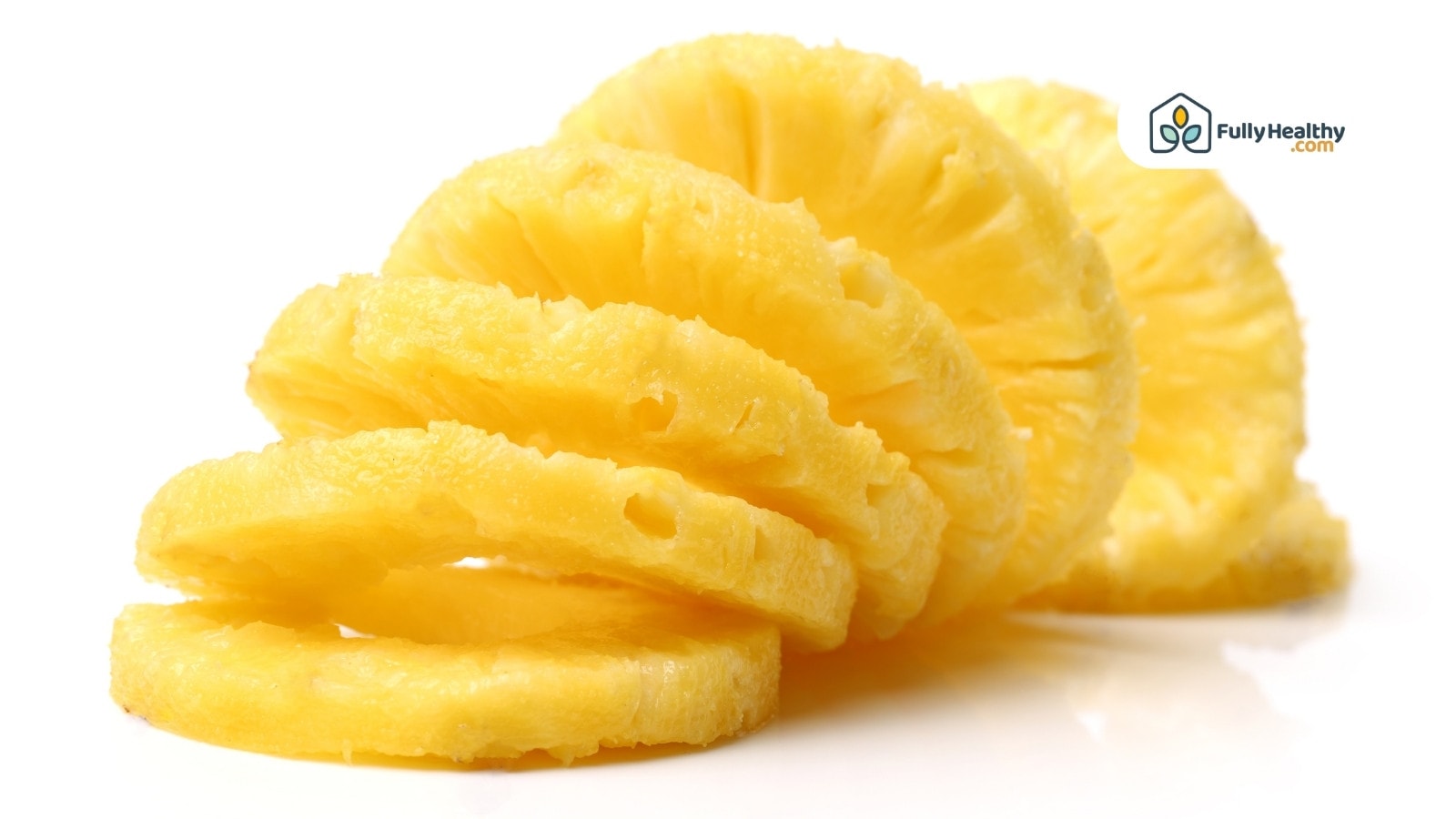 Sliced pineapple rings stacked on white background close-up view