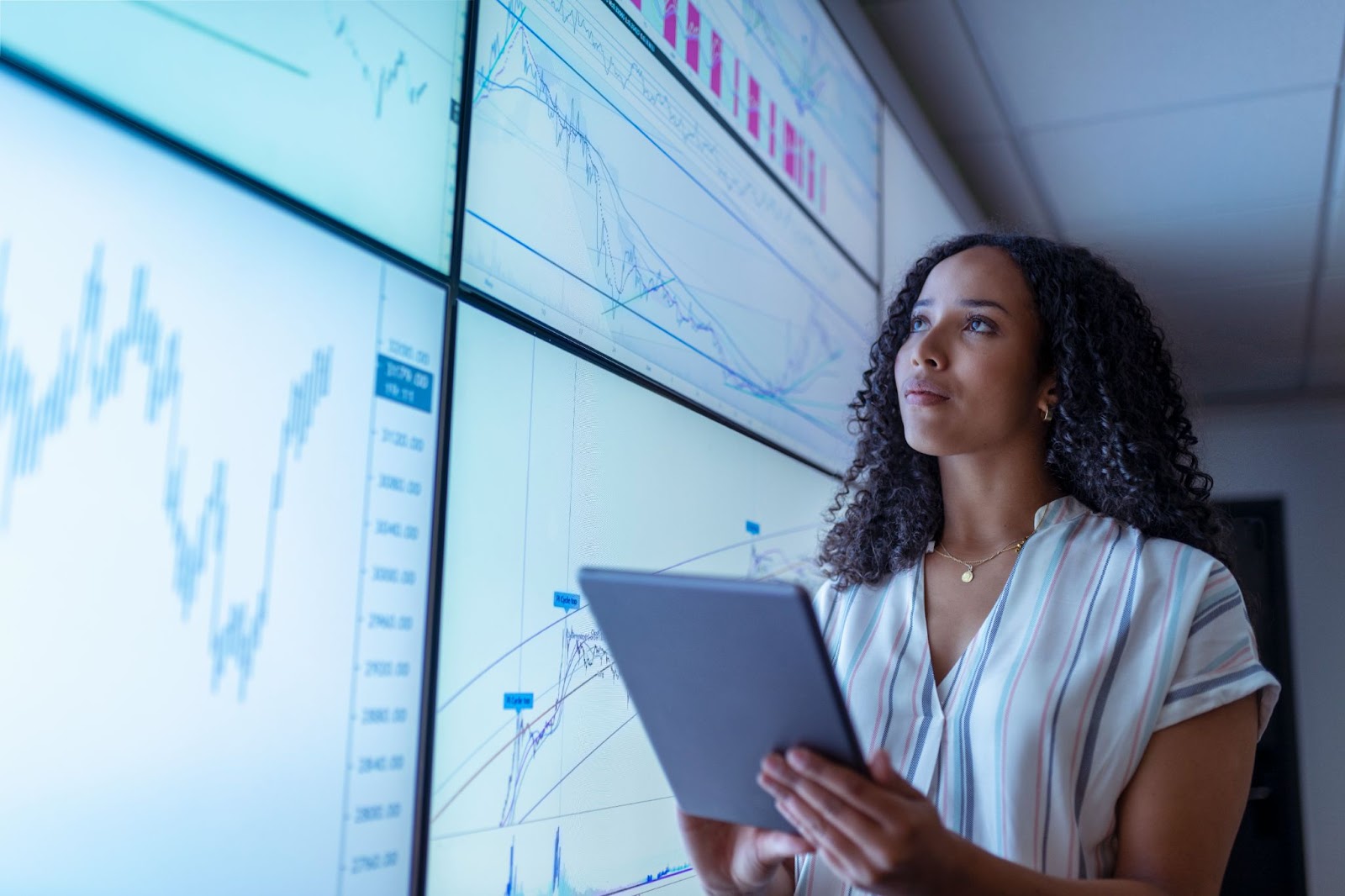 Woman using a tablet and checking data on a screen. 