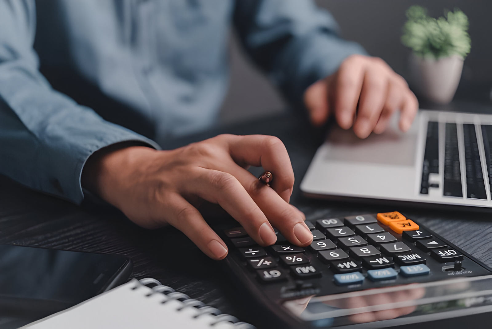 Person using a calculator and laptop, illustrating the concept of bookkeeping as a great business idea.