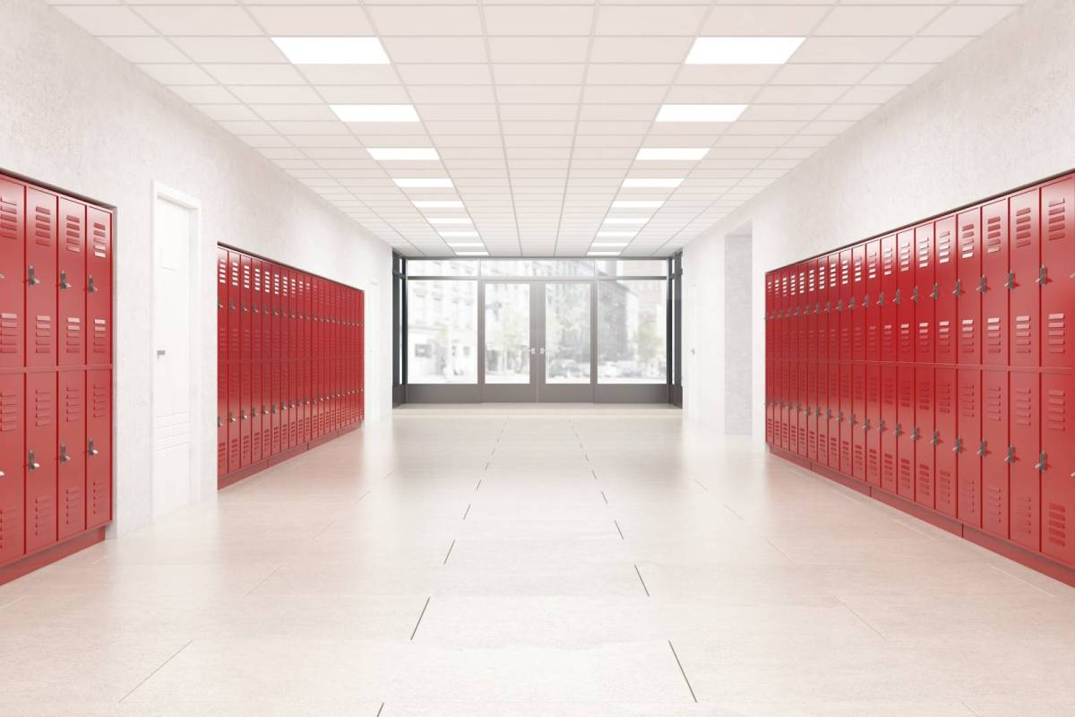 An empty school hallway lied with red lockers