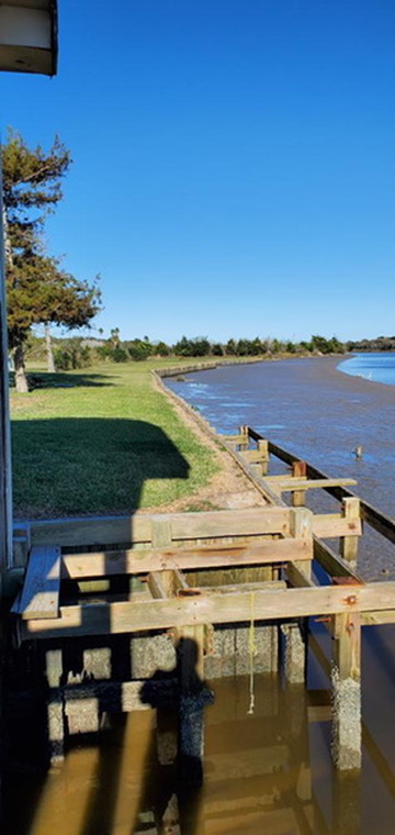 Wood pilings in the ocean for beach house foundation stability