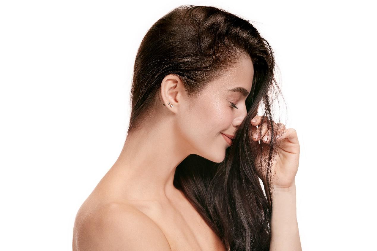 A person holding her hair

Description automatically generated