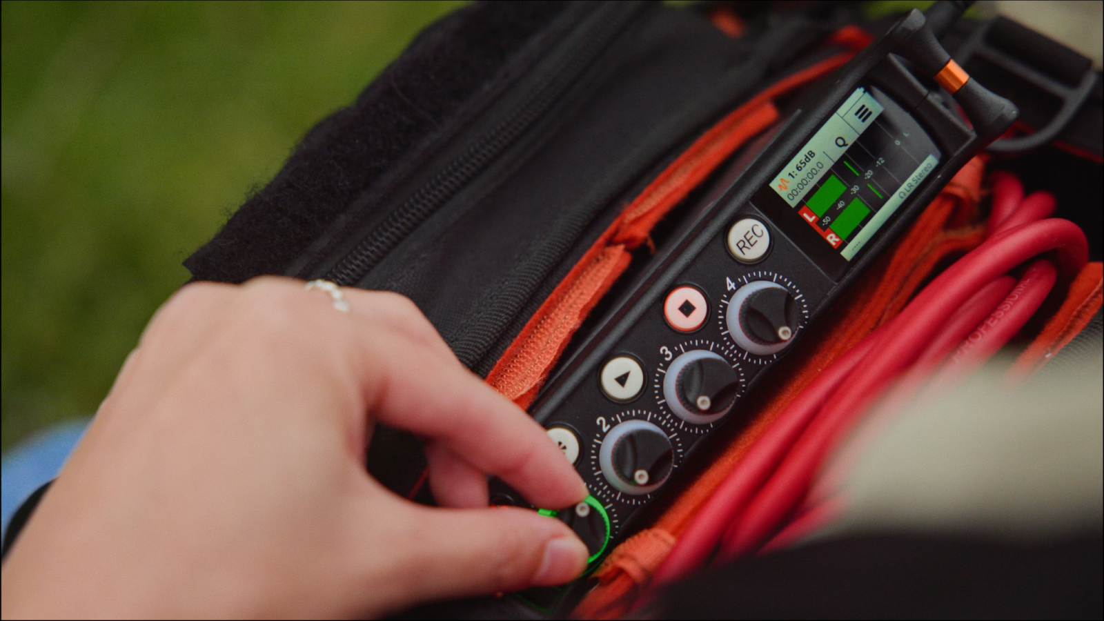 Close-up of hand adjusting audio equipment. 