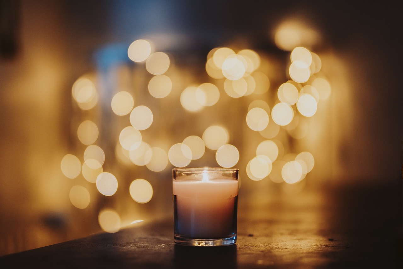 softly lit candle in glass holder