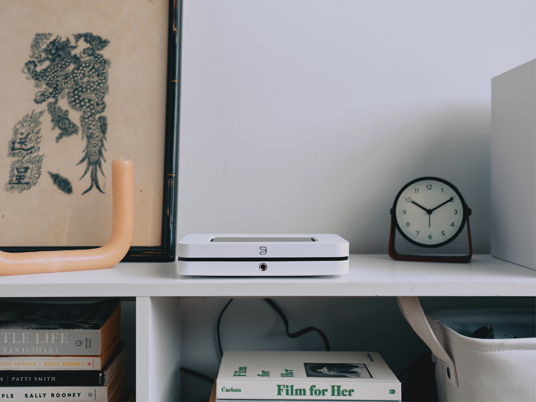 A white shelf with a clock and a picture on it

Description automatically generated