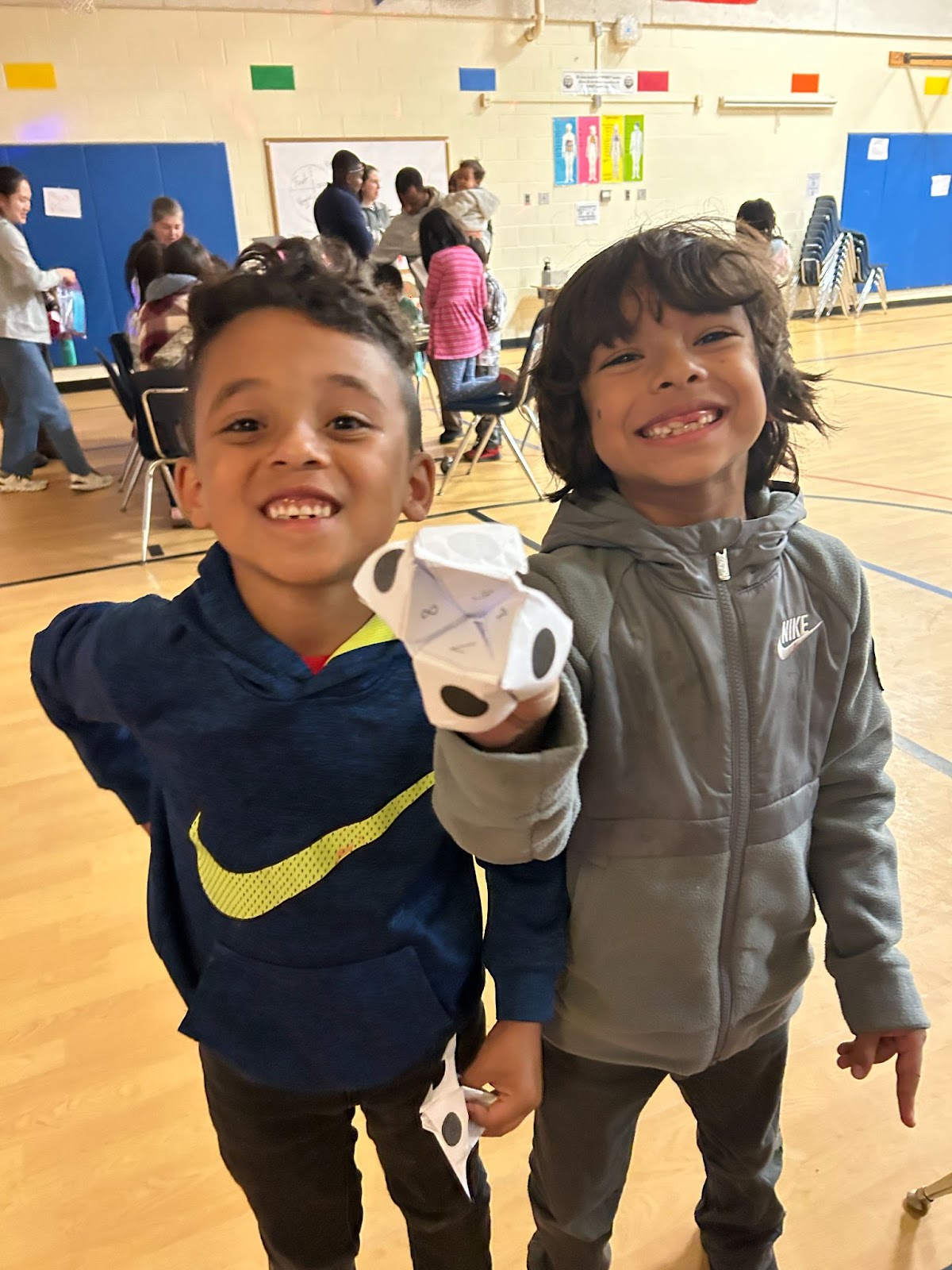 Two elementary age students smile while holding a paper fortune teller at Bonnie Brae Elementary School. 