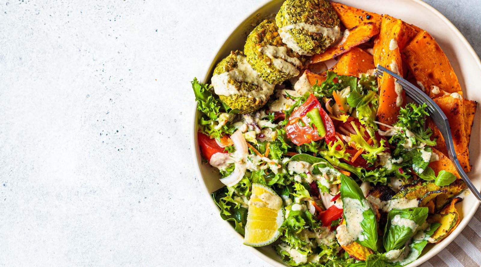 A vibrant salad bowl with falafel, sweet potatoes, and fresh greens, offering a nutritious meal option at a Kanata restaurant.