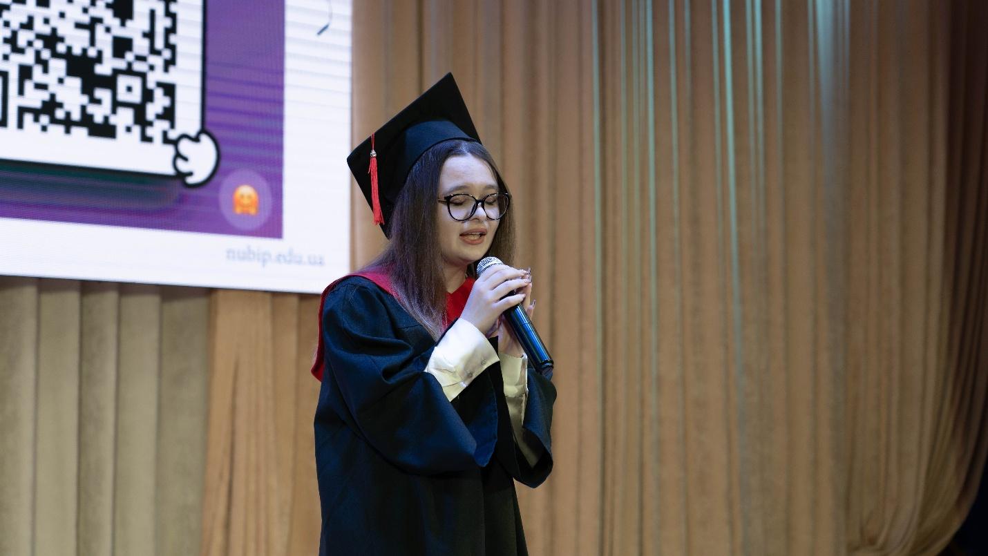 A person in a graduation gown holding a microphoneAI-generated content may be incorrect.