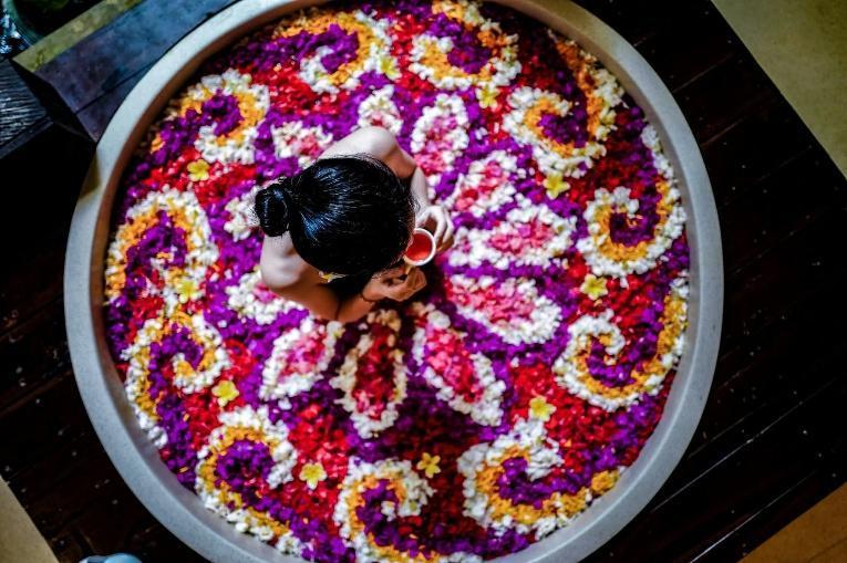 A person in a tub of colorful flowers

AI-generated content may be incorrect.