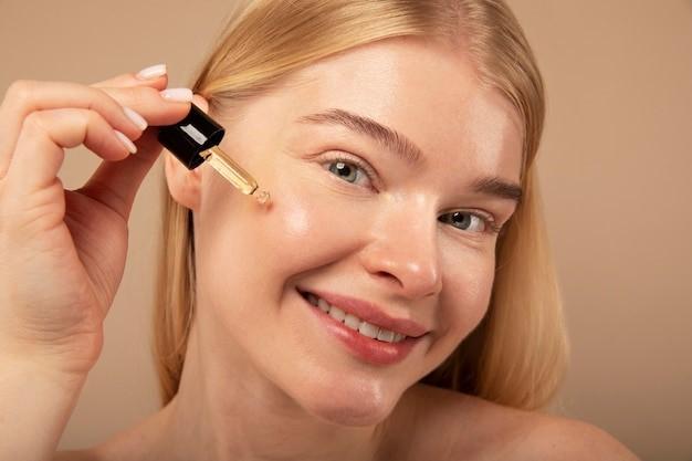 close up smiley woman using serum, Picture