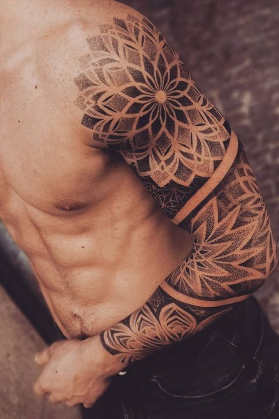 Close-up of a muscular man with an intricate geometric full sleeve tattoo on his right arm.