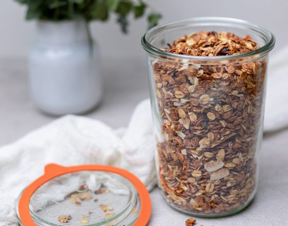 A tall glass jar of granola.