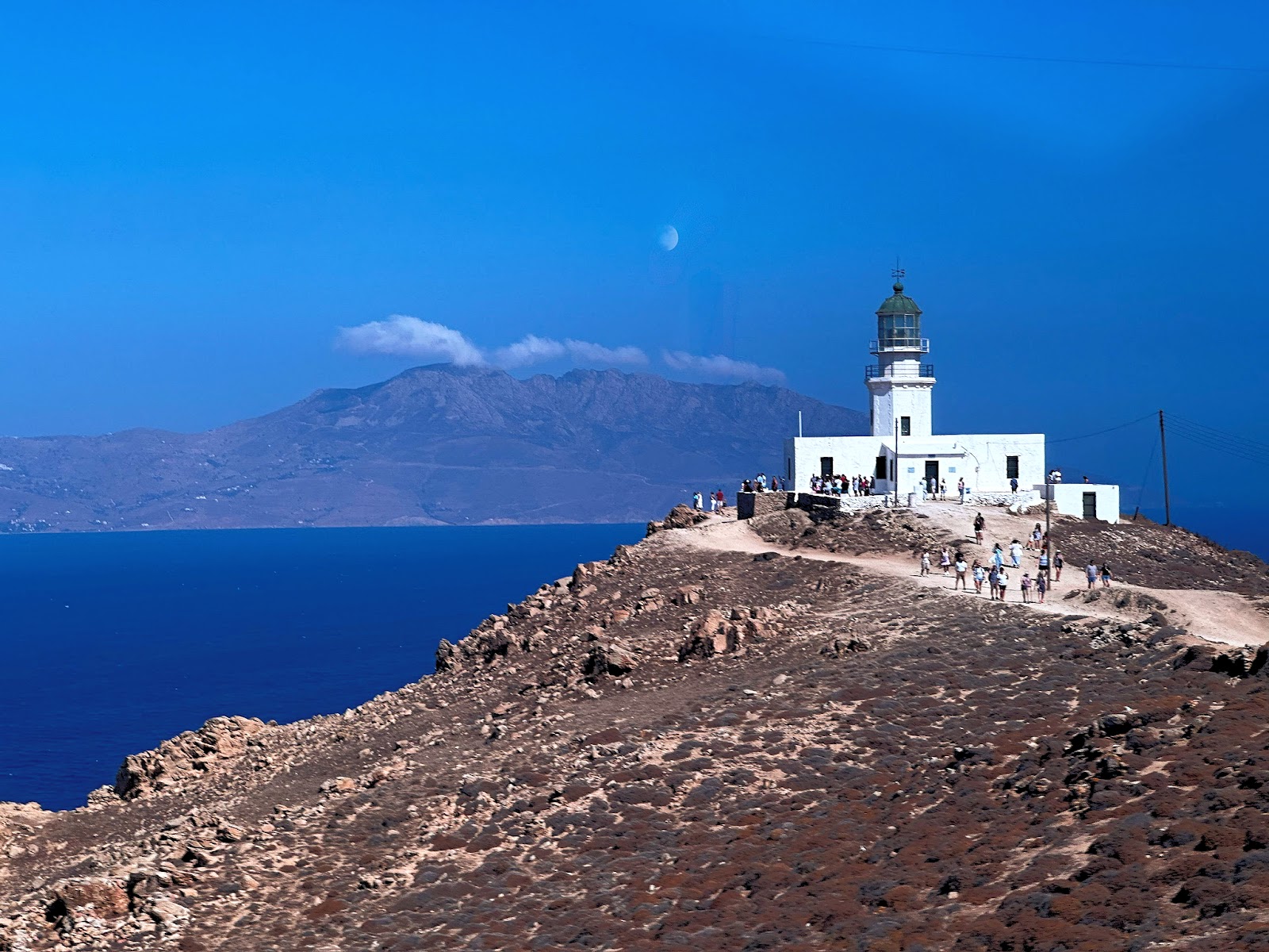 The Windmills of Mykonos, view of a building sitting on a cliff over water