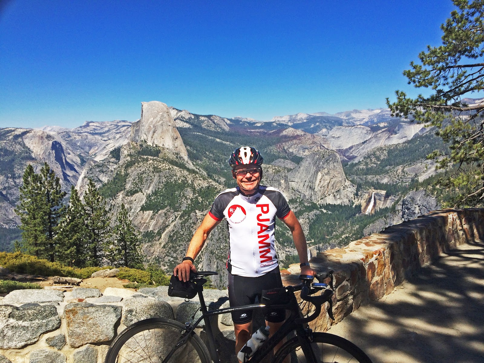 Cycling California top bike climbs - cyclists with bike with half dome and Nevada and Vernal falls in background