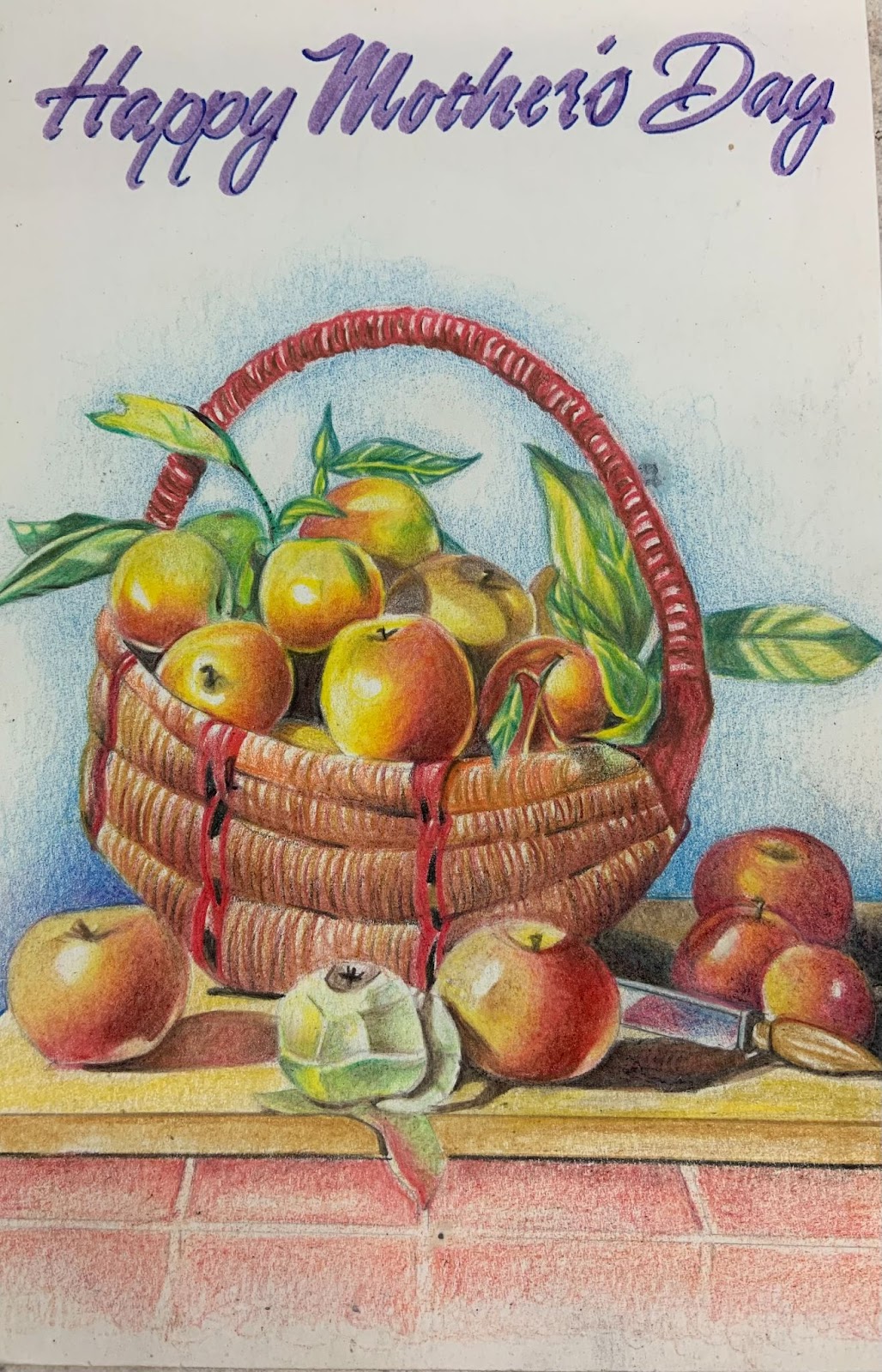 Image: Life is Life by Mike Sullivan, 2018. A colorful graphite still life of  a wicker basket filled with apples, their leaves still attached. Several red and yellow apples surround the basket. One is peeled away. Image courtesy of Mike Sullivan.