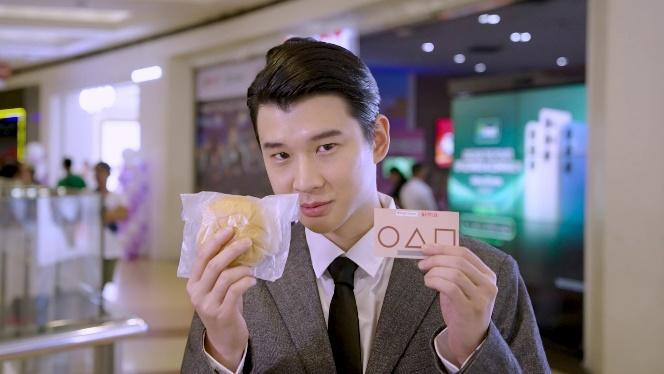 A person holding a sandwich and a card

AI-generated content may be incorrect.