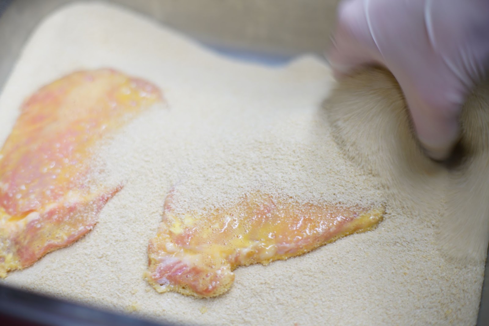 cutlets being coated with bread crumbs