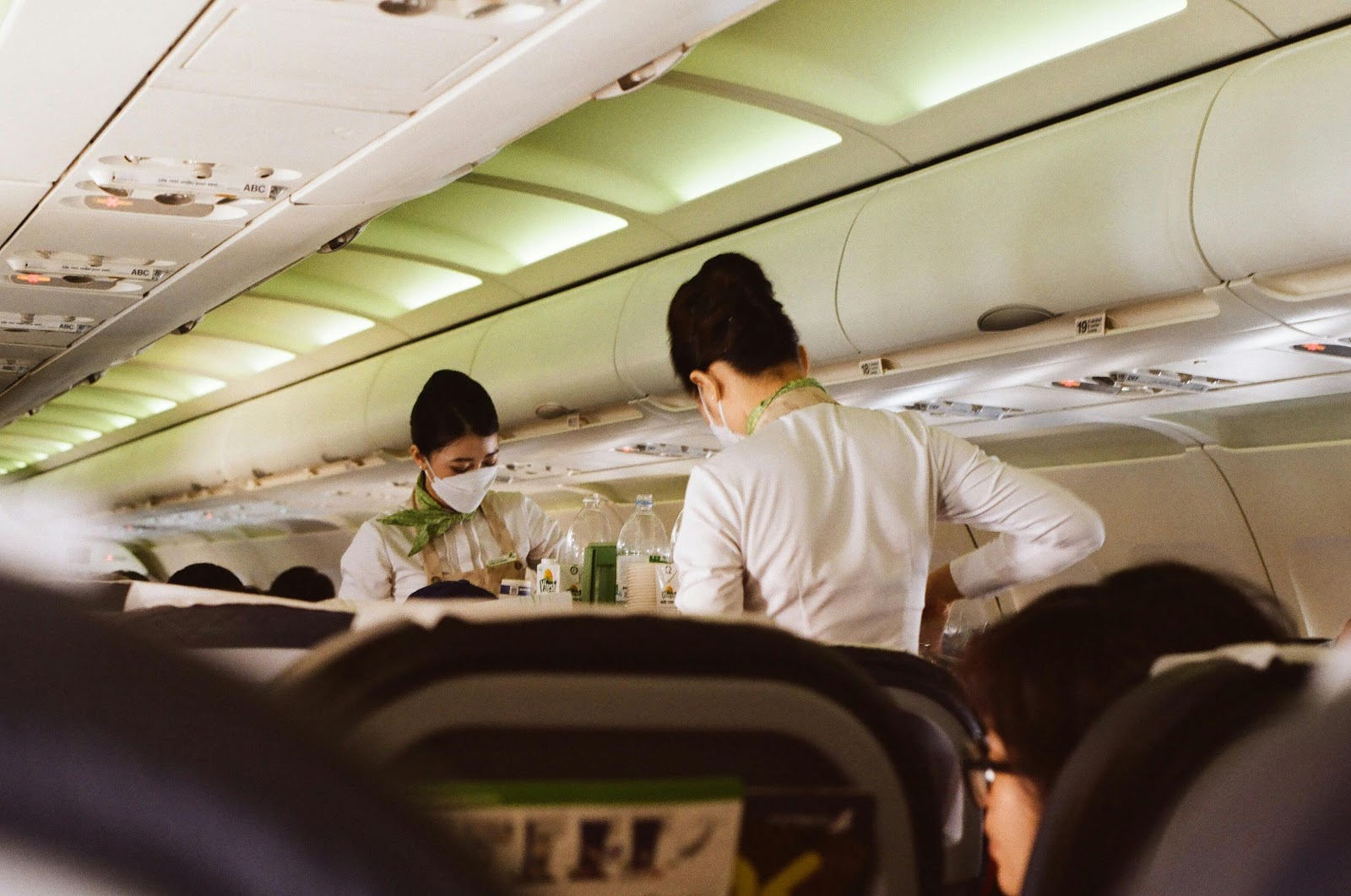 Two flight attendants servicing passengers | Source: Pexels