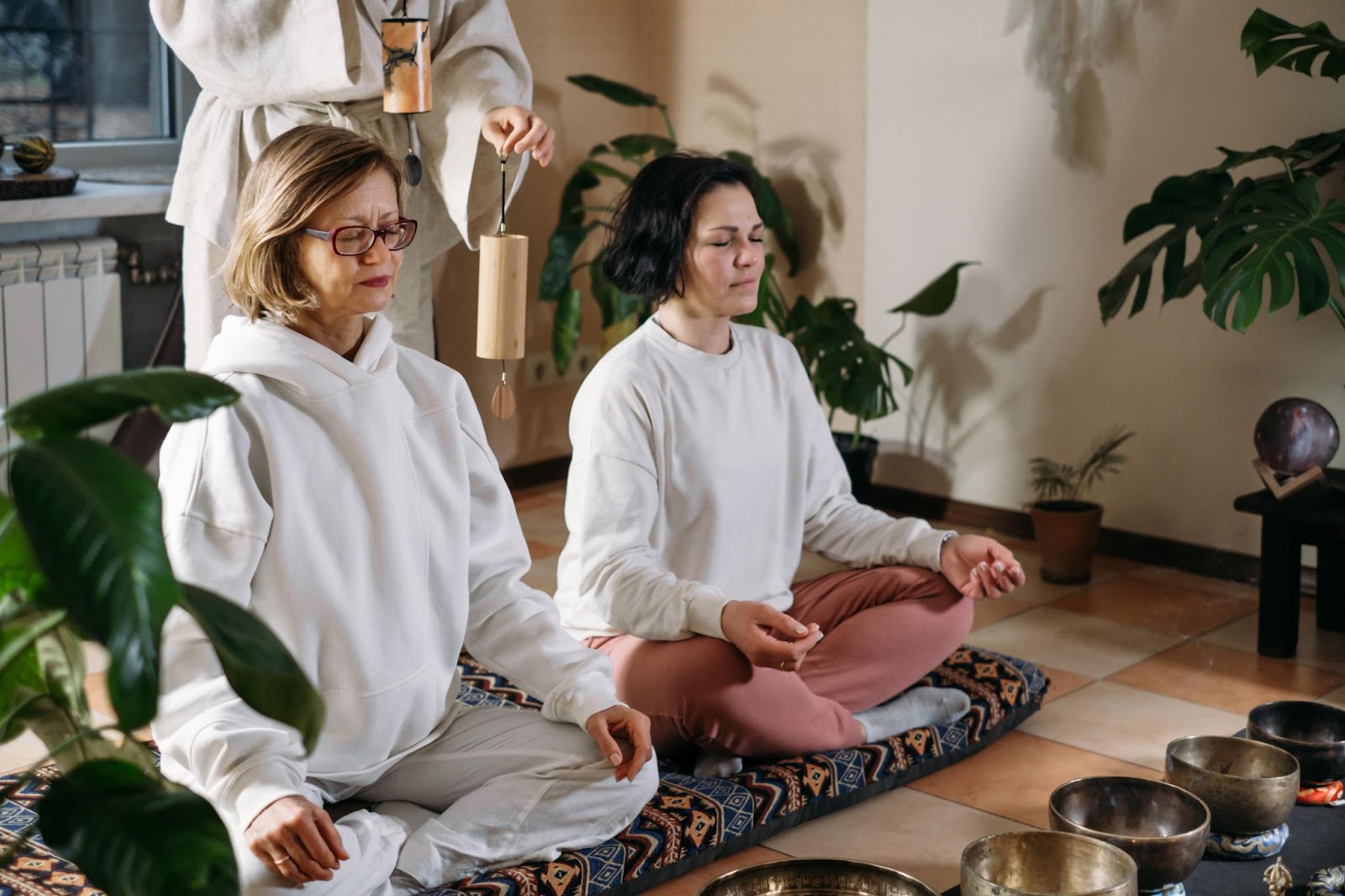 Two women sitting on the floor enjoying a sound bath during a retreat.