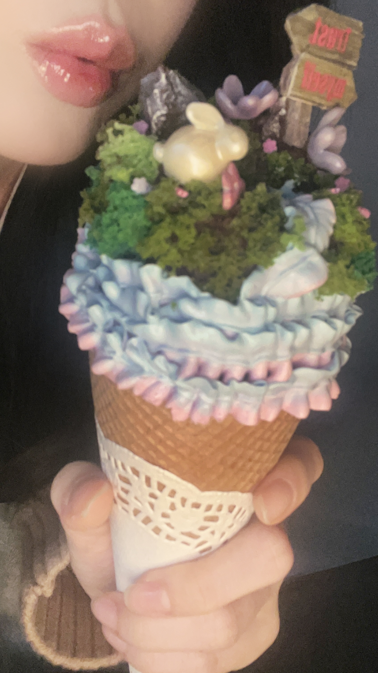 A photo shows a beautifully decorated ice cream cone with swirls of pastel colors and sparkling toppings