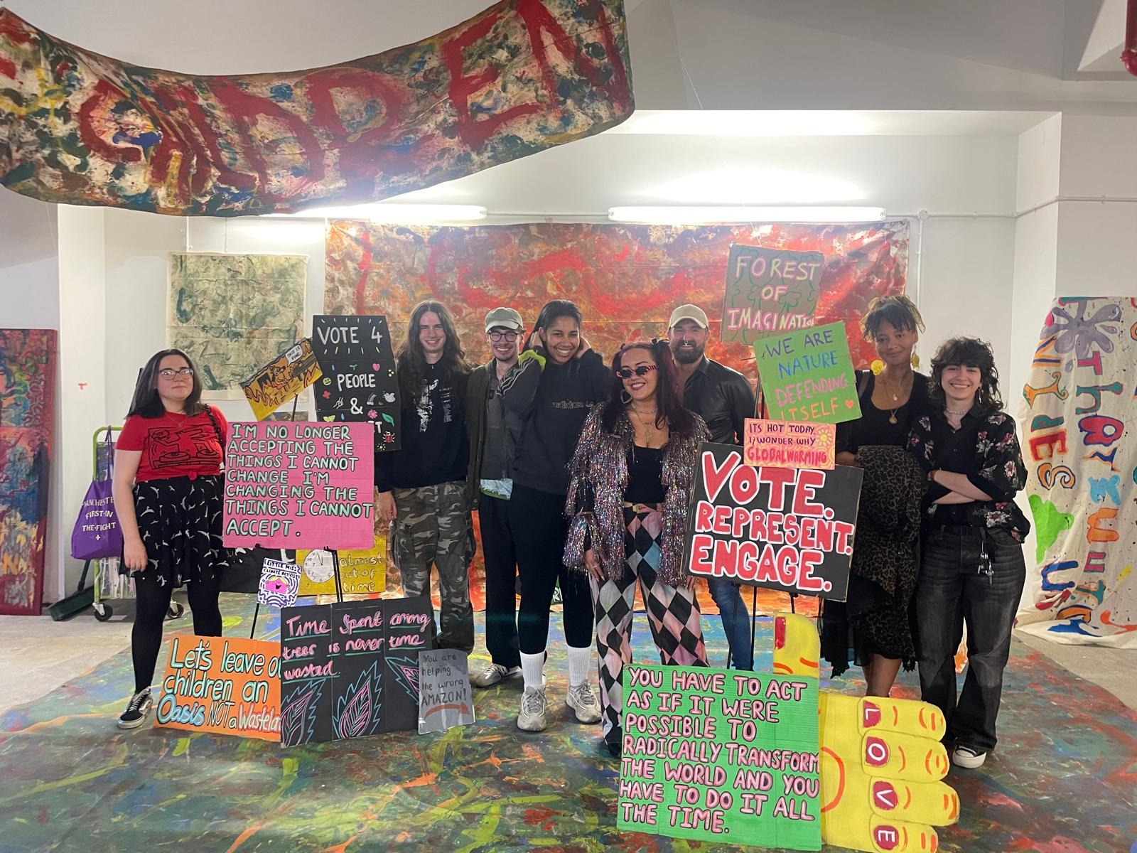 A group of people standing in a room with signs

Description automatically generated