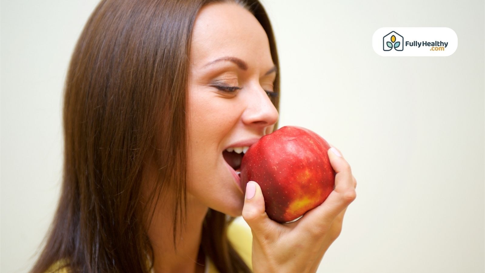 Woman enjoying a red apple promoting healthy teeth and gums
