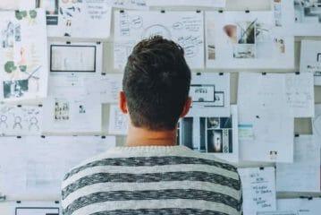 the man is looking at the blackboard with his notes