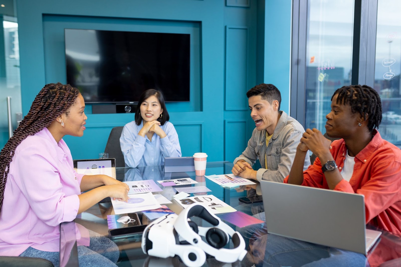 A diverse group of young colleagues discussing product launches around a conference table, collaborating as a startup business team.