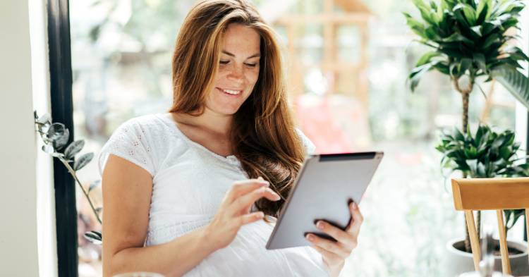 woman smiling using tablet